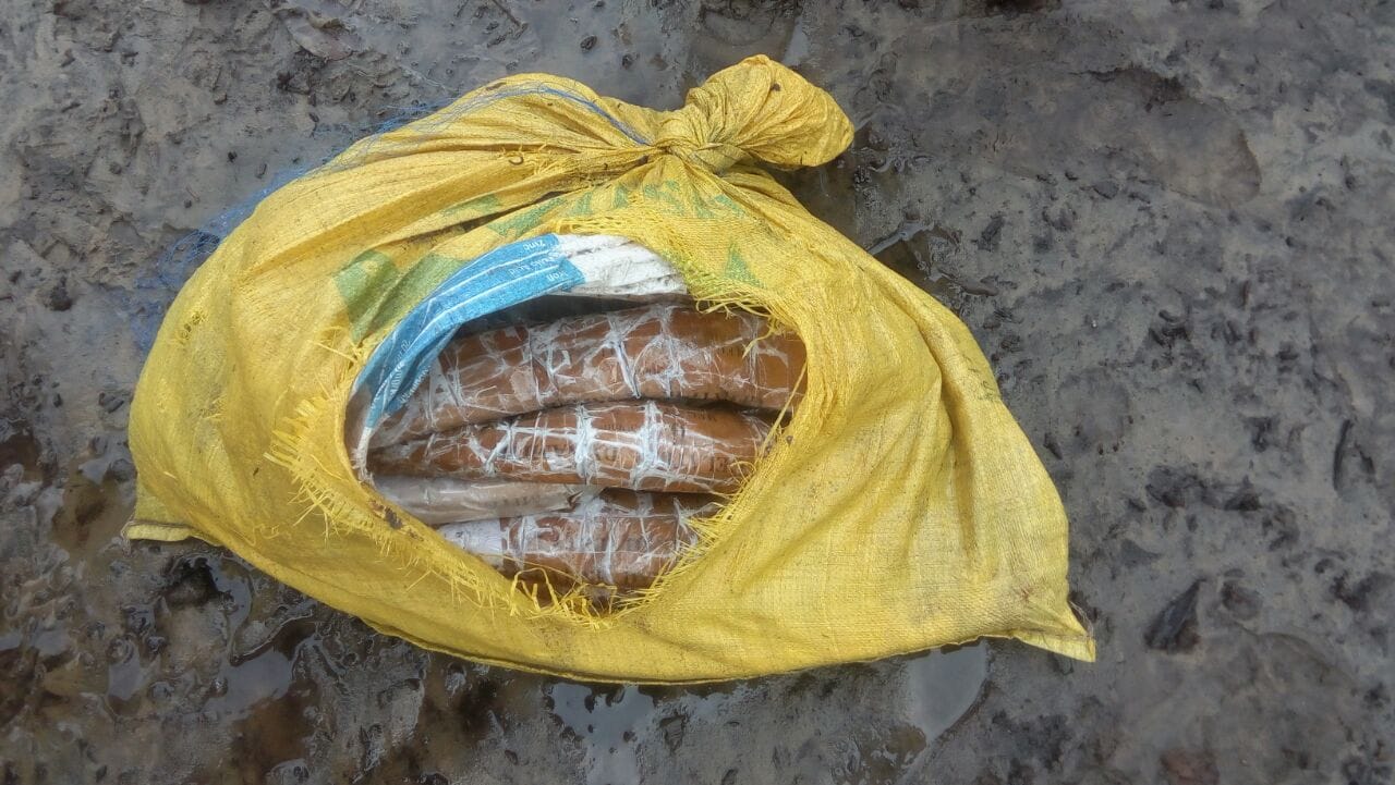 Open yellow sack containing several wrapped cylindrical items